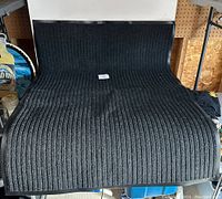 Top view of gray ribbed entrance mat with black rubber border, showing size and texture