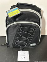 Front view of black Gear Tech insulated lunch bag showing zippered front pocket with bungee detail and top handle, tag attached.