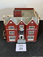 Front view showcasing red brick facade with white window trims and front entrance with two figurines.