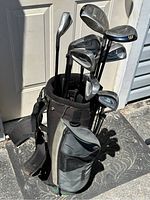Full view of the Mizuno left handed golf clubs in a black and gray golf bag showing woods and irons with assorted club heads visible.