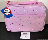Front view of pink lunch bag with multicolored hearts and tag indicating 100% PVC free material.