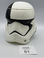 Front view of white and black Stormtrooper helmet popcorn bucket with visible minor marks and scratches.