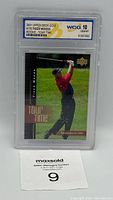 Front view of the graded Tiger Woods rookie card in its protective slab showing the golf pose and the grading label.