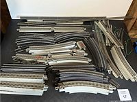 Overview photo showing a large variety of HO scale train track pieces including multiple straight, curved, and turnout tracks.