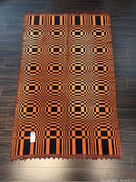 Entire rug laid flat on dark flooring, showing full geometric pattern