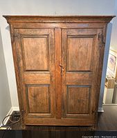 Full front view showing double-paneled doors, crown molding and base