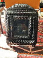 Angled front view of cabinet leaning against chair on patterned rug