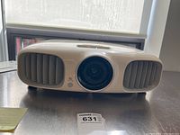 White Epson projector front view showing lens and ventilation grills