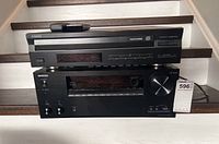 Front view of Onkyo receiver below and Yamaha CD player above on staircase steps