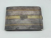 Closed front view showing alternating silver and gold bands with central cartouche monogrammed RHR.