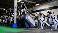 Row of Matrix elliptical and cardio machines in gym interior