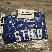 Sealed royal blue Toronto Blue Jays jersey with 'Stieb' name bar and number, wrapped in plastic with a Frameworth Sports Marketing card