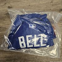 Folded Toronto Blue Jays jersey in clear plastic bag showing 'BELL' on back