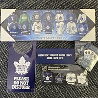 All collectible items displayed on floor: playing cards, door knob sign, game-used net display box, fridge magnets.