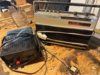 Photo showing the Record Boy transistor radio and Pyramid regulated power supply placed side-by-side with cables tangled and some wear visible.