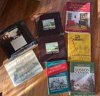 Overview photo of all 8 books arranged on floor showing variety of titles and colors of dust jackets and covers.