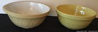 Both ceramic mixing bowls side by side on a flat surface, showing exterior colors and shapes