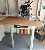 Full view of the Delta ShopMaster scroll saw mounted on metal stand with work surface and power cord visible.