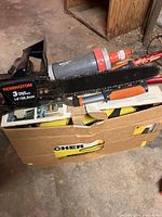 Remington electric chainsaw partially resting on cardboard box with visible Karcher label