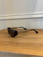 Side angled view showing black front frames and gold-tone temples with CK logo