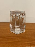 Frontal view of sculptural glass head with stylized facial features