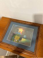 Framed animation cell showing Leonardo in sewer lair setting, wood frame with blue matting.