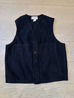 Front view of the black Filson vest showing five-button closure and two front pockets.