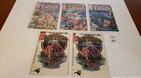 Five Tarzan Marvel Comics laid out side by side showing covers and condition.