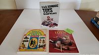Set of three books on collecting toys, games and dolls, showing titles and cover art.