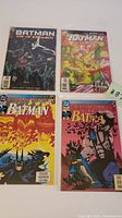 Four DC Comics Batman comic books displayed together showing covers of Batman Day of Judgment, Batman Final Crisis, Batman No Man's Land, and Detective Comics Batman.