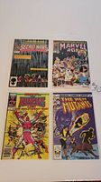 Four Marvel comic books displayed: Secret Wars #4, Marvel Age #73, What If #1, The New Mutants #1