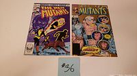 Photo of two comic book issues The New Mutants #1 and #87 2nd Print shown side-by-side face-up.