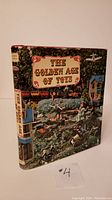 Front cover of The Golden Age of Toys book with colorful dust jacket showing toy train and buildings.