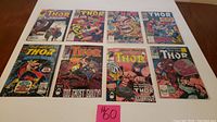 Eight comic books of Marvel's The Mighty Thor laid out flat, showing colorful front covers with various action scenes.