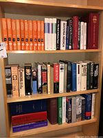 Mounted bookshelf filled with a set of orange medical volumes and various historical/medical books.