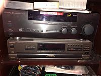 Front view of Kenwood VR-606 stereo receiver and Technics SL-PD857 CD player stacked together on a shelf, showing details of buttons and display.