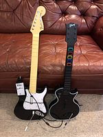 Both guitars front view showing Fender and Gibson style bodies, cables, and whammy bars