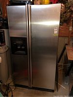Front view of stainless steel Kenmore side-by-side refrigerator with water and ice dispenser on left door.