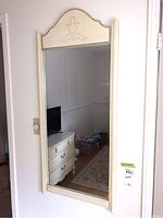 Full view of the mirror mounted on a wall, showing its overall shape and size.