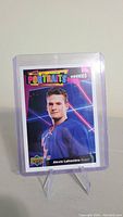 Front side of Alexis Lafreniere rookie card showing player portrait in blue Rangers jersey, with colorful UD Portraits Rookies design.