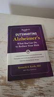 Front cover of the book 'Outsmarting Alzheimer's' by Kenneth S. Kosik, MD, showing title and author.