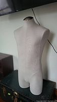 Male full body tailor's dummy mannequin torso in beige fabric, front angled view