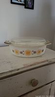 Front view of Pyrex Town & Country casserole dish with clear glass lid on a white wooden surface.