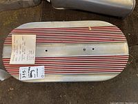 Top view of vintage finned aluminum air cleaner with red fins and handwritten note detailing dimensions and spacing.