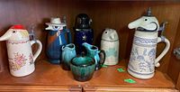 Shelf display of sugar bowl set and five beer steins