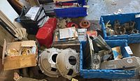 Overview of assorted parts in bins including adapters, valve covers, manual