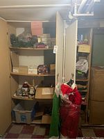 Shelves with various Christmas decorations including wreaths, ornaments, storage boxes, and wrapped costumes.