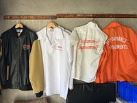 All four garments hung on wooden rods showing entire lot