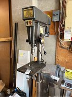 Full front view of floor-standing drill press showing column, adjustable table and head