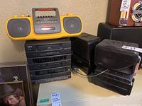 RCA stereo system model RP9115 with CD player, cassette decks, and control panel, alongside four Genexxa speakers